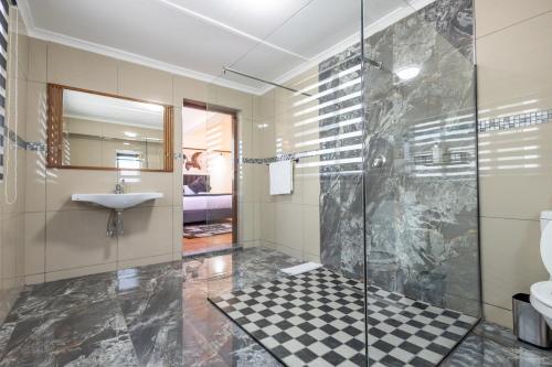 un baño con ducha y lavabo en Dazzle Stay, en East London