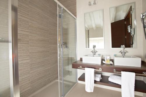 a bathroom with two sinks and a shower at Hotel Termas Balneario Termas Pallares in Alhama de Aragón