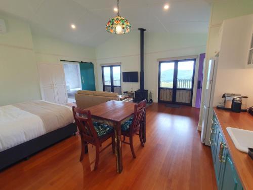 a bedroom with a dining room table and a bed at Couples Accessible Cabin, Zarina Country Cabins, 6 in Witta