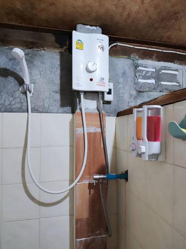 a shower in a bathroom with a hose attached to the wall at Baan pai Hostel in Pai