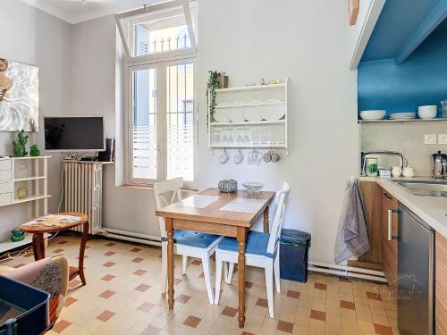 une cuisine avec une table, des chaises et un évier dans l'établissement Apartment Jeanne, à Carcassonne
