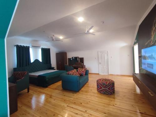 a living room with two blue couches and a flat screen tv at Anor in Tashkent