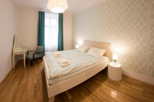 a bedroom with a bed with a desk and a chair at Fresh Apartments in Krakow