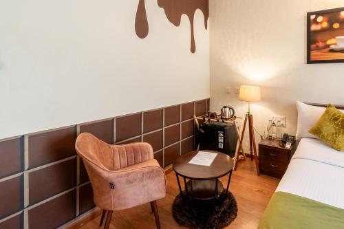 Camera con letto, sedia e tavolo di Chocolat house a Bangalore