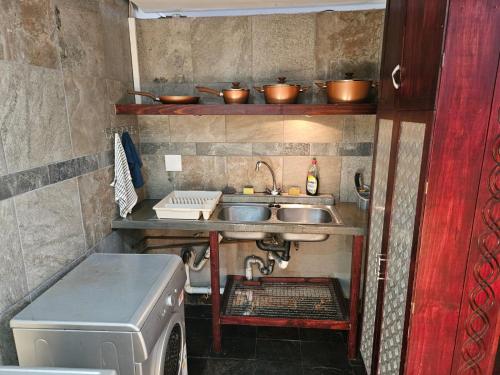 a kitchen with a sink and a washing machine at 62 on Tuzi Gazi in Richards Bay