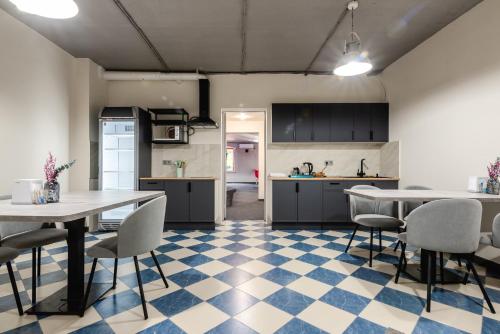 a kitchen and dining room with tables and chairs at AYKUN Capsule Hotel in Almaty