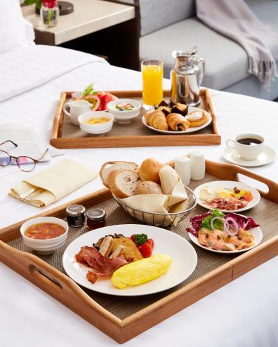 a tray of breakfast foods on a table in a hotel room at Conrad Bangkok in Bangkok