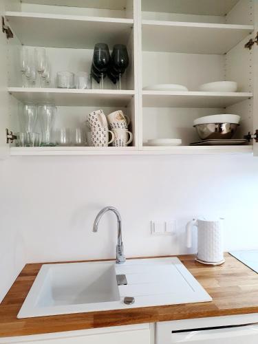 a kitchen counter with a sink and shelves at Pobierowo City in Pobierowo