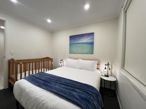 a bedroom with a bed with a blue blanket at No Stairs, Big House, Garage Richmond Residence 2 in West Richmond