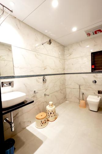 a bathroom with a sink and a toilet at Hotel Grand Haveli in Achād