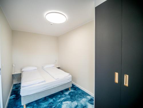 a small room with a bed and a cabinet at Art Boulevard in Mrzeżyno
