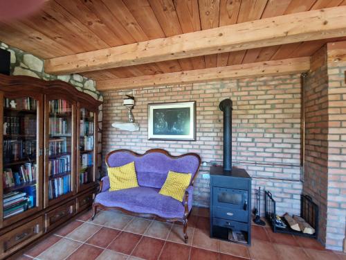 a living room with a purple chair and a stove at Harcówka in Miękisz Nowy