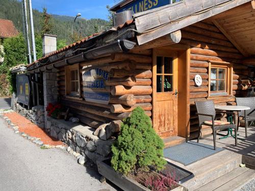 a log cabin with a table in front of it at Camping Dreiländereck Blockhütten & Apartments in Ried im Oberinntal