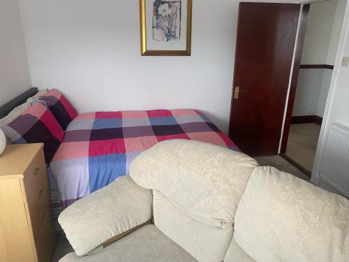 a bedroom with a bed with a colorful blanket at Queens House in Plymouth
