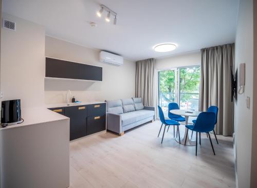 a kitchen and living room with a table and chairs at Art Boulevard in Mrzeżyno