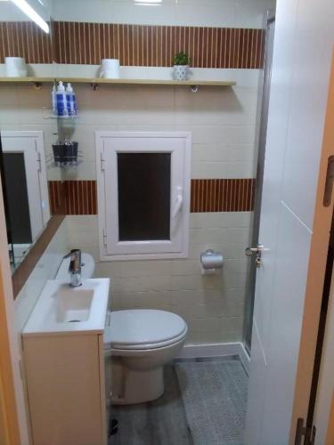 a small bathroom with a toilet and a sink at Encanto Cuenca - Puente Del Tiempo in Cuenca