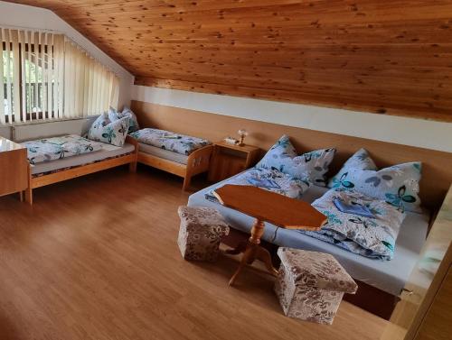 a room with two beds and a table and chairs at Vila Danka in Veľký Meder