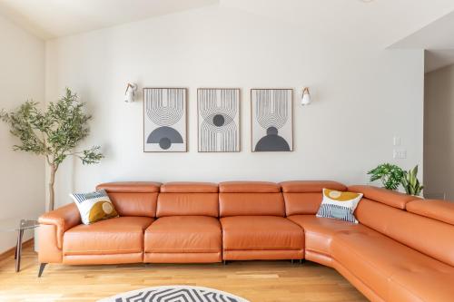 an orange couch in a living room with four pictures on the wall at Luxury Home - Reading & Game Room - Outdoor Dining home in Bellingham