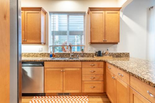 a kitchen with wooden cabinets and a sink and a window at Luxury Home - Reading & Game Room - Outdoor Dining home in Bellingham