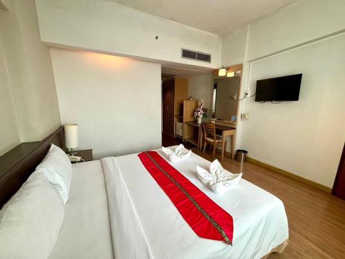 a hotel room with a white bed with a red blanket at Aloha Hatyai Hotel in Hat Yai