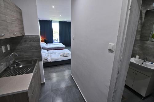 a bathroom with a sink and a bedroom with a bed at Penzión Šírava in Kaluža
