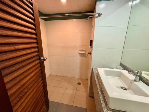 a bathroom with a sink and a shower with a mirror at Aloha Hatyai Hotel in Hat Yai
