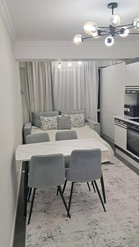 ein Schlafzimmer mit einem großen Bett und zwei Stühlen in der Unterkunft Уютный Дом in Chişinău