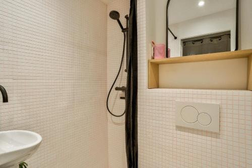 une salle de bain avec douche et lavabo dans l'établissement Charmant studio près du Marais, à Paris