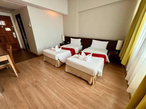 a hotel room with three beds in a room at Aloha Hatyai Hotel in Hat Yai
