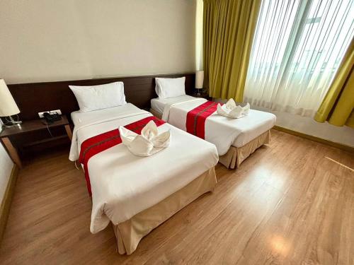 a hotel room with two beds with bows on them at Aloha Hatyai Hotel in Hat Yai
