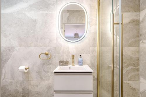 a bathroom with a sink and a mirror at Bungalow Close to South Downs & Beach in Angmering