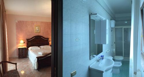 Un baño con lavabo, inodoro y una cama. en B&B Castello Michelina, en San Nicola dellʼAlto