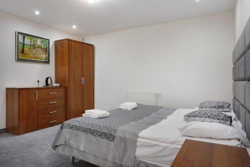 a bedroom with a large bed and a wooden cabinet at Hotel Pegaz in Krynica Zdrój