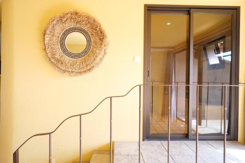 a hallway with a staircase and a mirror on the wall at Chambres du Vieux Bistrot in Cabrières-dʼAvignon
