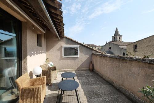 a small balcony with chairs and a table on a wall at Chambres du Vieux Bistrot in Cabrières-dʼAvignon