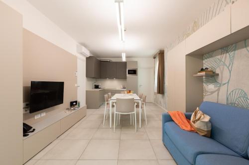 a living room with a blue couch and a kitchen at Villaggio Turistico Internazionale in Bibione