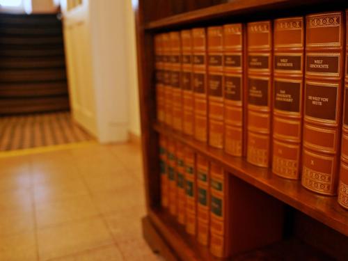 a row of books on a shelf in a library at Ferienwohnung im Hofratshaus in Schrozberg