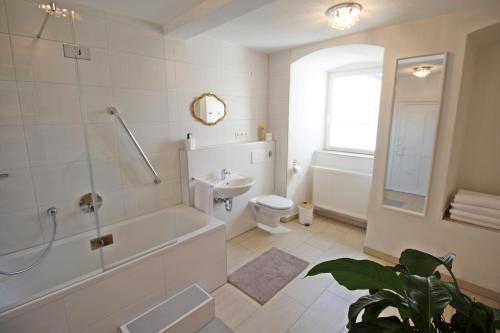 a bathroom with a tub and a toilet and a sink at Ferienwohnung im Hofratshaus in Schrozberg