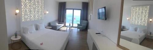 a white room with a white couch and a living room at Epirus Hotel in Sarandë