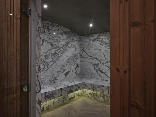 a bathroom with a marble wall with a tub at Atlantica Aegean Blue in Kolimbia