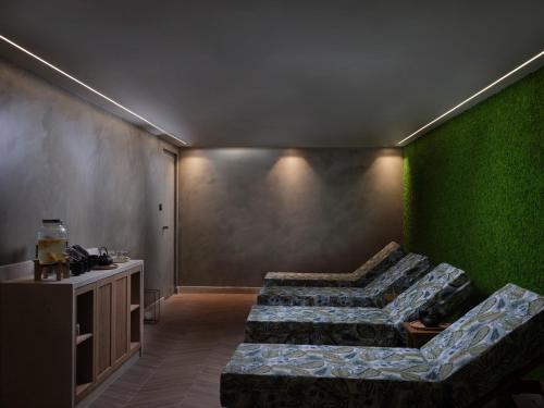a room with two beds and a green wall at Atlantica Aegean Blue in Kolimbia