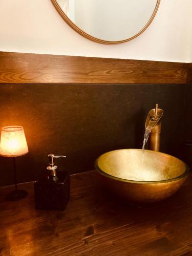 a bathroom with a wooden bowl sink and a lamp at Domus Mylae in Milazzo