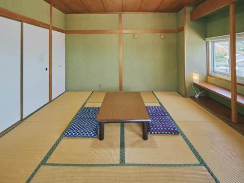 a room with a table in the middle of a room at Guest Living Mu Nanki Shirahama in Shirahama