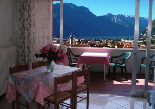 a balcony with a table and chairs and a view of the mountains at Residence Cascata Varone in Riva del Garda