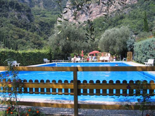a swimming pool with a wooden fence around it at Residence Cascata Varone in Riva del Garda