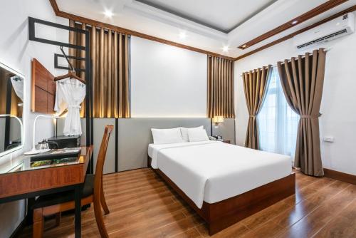 a bedroom with a bed and a desk and a television at A25 Hotel - 44 H&agrave;ng B&uacute;n in Hanoi