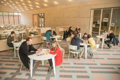 a group of people sitting at tables in a restaurant at Hostel Groeninghe in Kortrijk