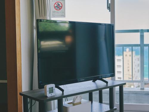 a flat screen tv sitting on a table next to a window at Guest Living Mu Nanki Shirahama in Shirahama
