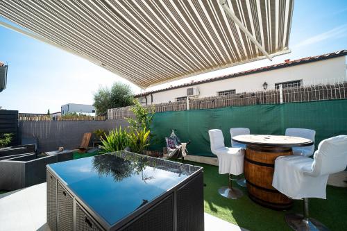 a patio with a table and chairs and a barrel at Bienvenue chez Sandyan- A 15 minutes de la plage in Rivesaltes
