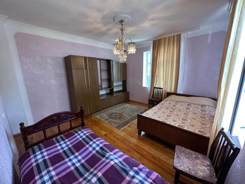 a bedroom with a bed and a chandelier at Vandam Luminous Villa in Gabala
